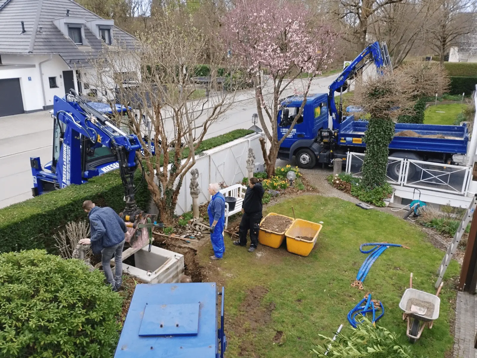 Tiefbauarbeiten im Garten mit Kiesel und Söhne Fahrzeugen